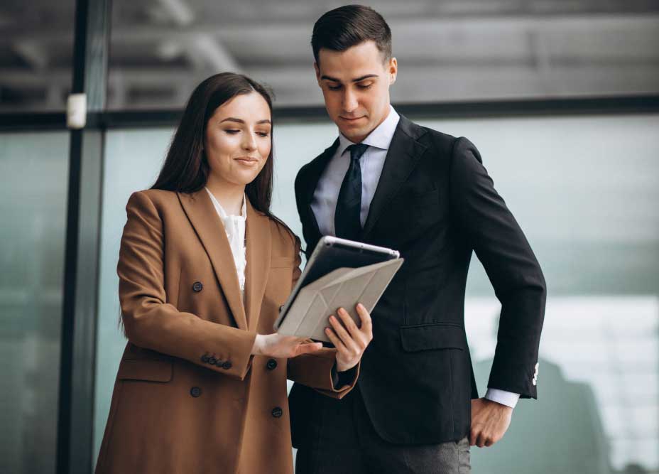 Business Financial Consultant Miami reviewing financial data on a tablet with a client in a professional office setting