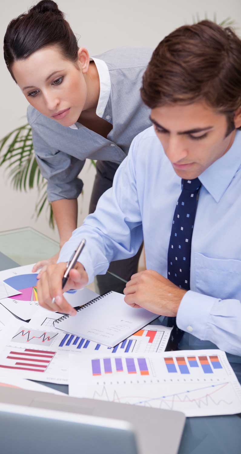 Professional accounting team reviewing financial documents and reports in an office meeting, providing reliable cpa boca raton services