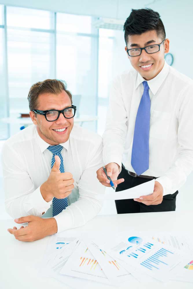 Two accounting professionals reviewing financial reports together in a bright office, providing reliable bookkeeping services Fort Lauderdale for clients