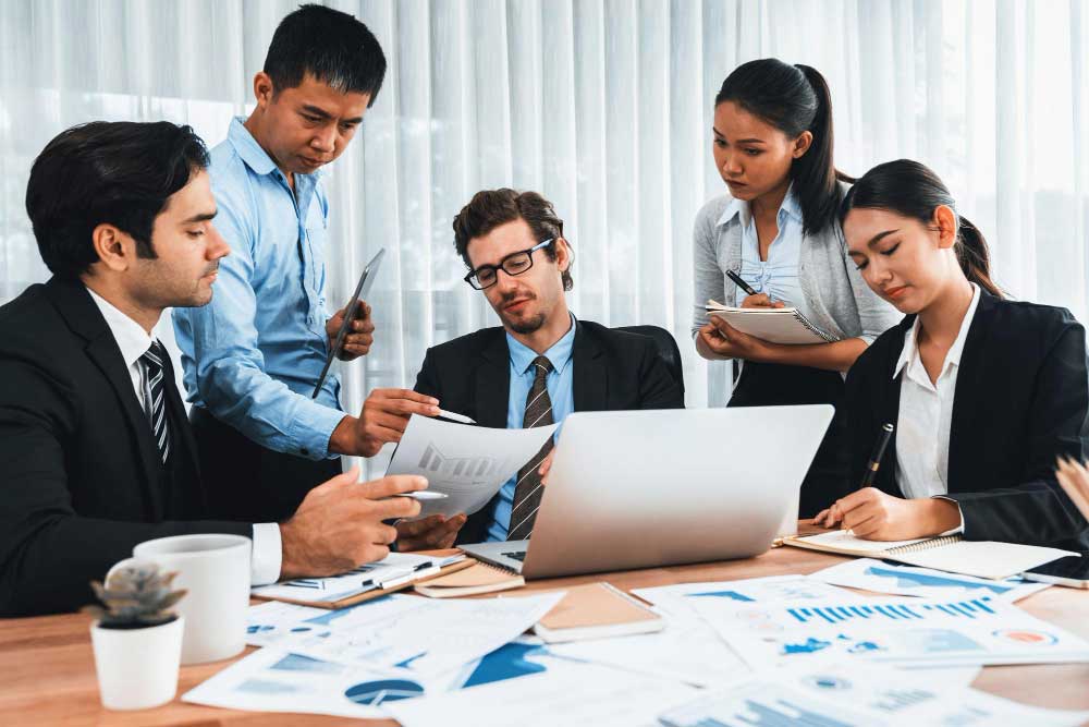 Professional accounting team reviewing financial documents and reports in an office meeting, providing reliable cpa boca raton services