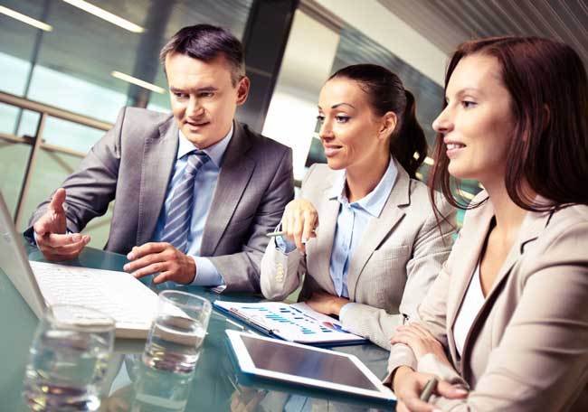 Business professionals collaborating on financial reports in a modern office meeting, showcasing expert cpa boca raton accounting services