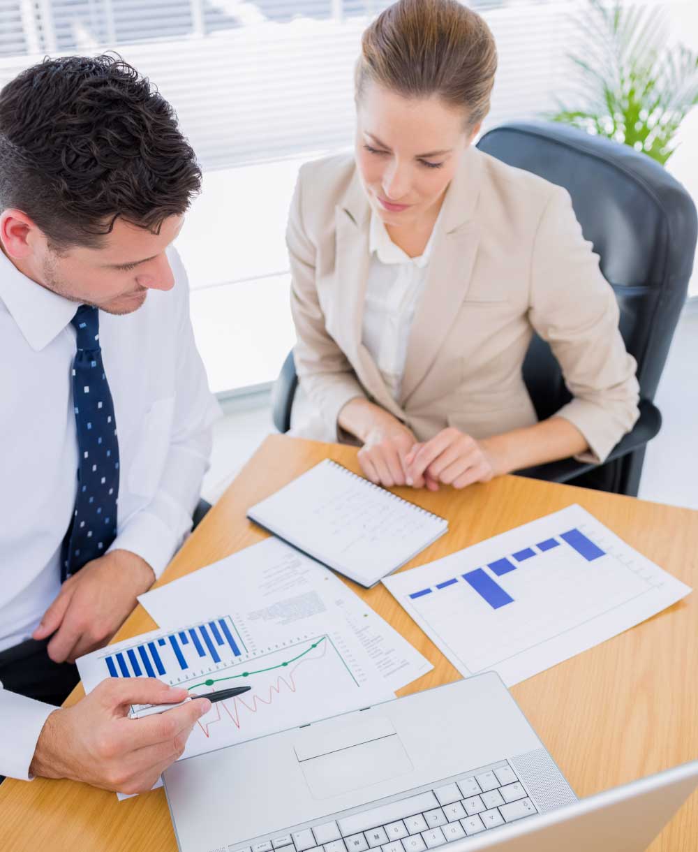 Professional accounting team reviewing financial documents and reports in an office meeting, providing reliable cpa boca raton services